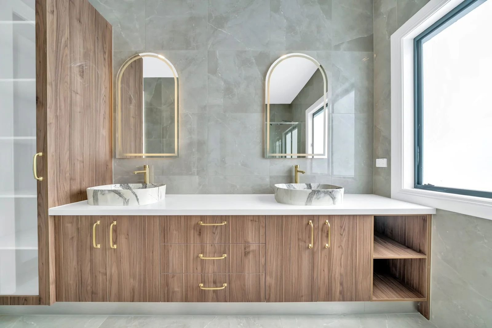 Double vanity with arched mirrors and brass tapware