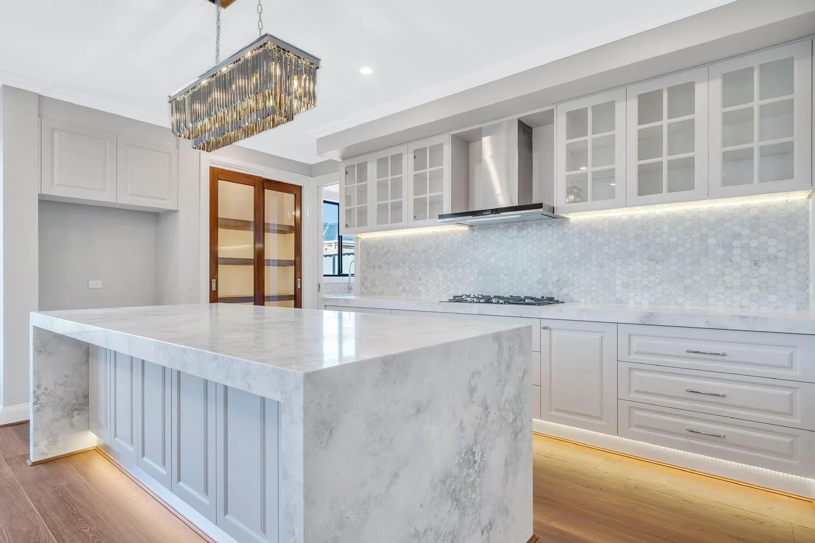 White kitchen with marble waterfall island