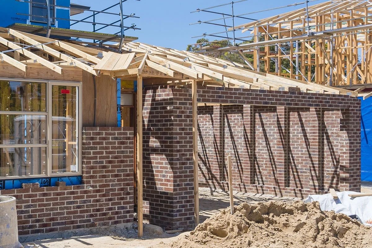 Brickwork and roof trusses at lockup stage of a new home
